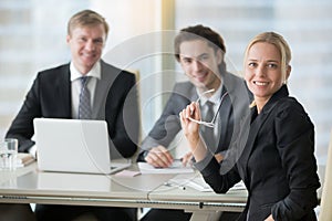Group of smiling businessmen at the modern office desk