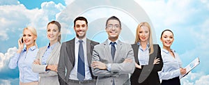 Group of smiling businessmen over blue sky