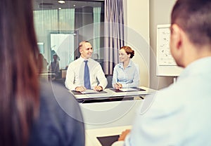 Group of smiling businesspeople meeting in office