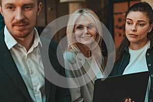 Group of smiling coworkers is talking during break time in office. Corporate unity concept