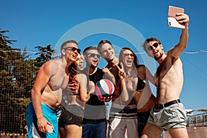 Group of smiling european friends making selfie on beach
