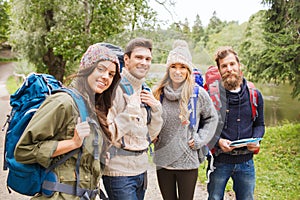 Group of smiling friends with backpacks hiking