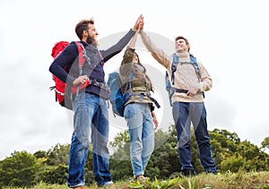 Group of smiling friends with backpacks hiking