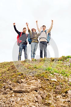 Group of smiling friends with backpacks hiking