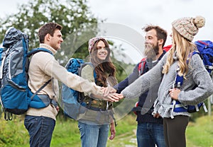 Group of smiling friends with backpacks hiking