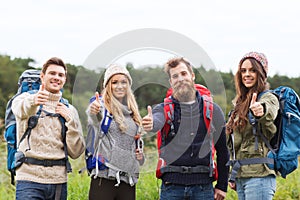 Group of smiling friends with backpacks hiking