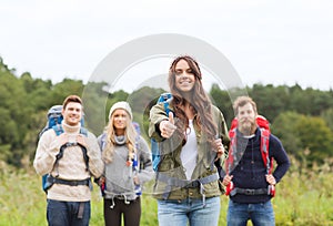 Group of smiling friends with backpacks hiking