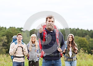 Group of smiling friends with backpacks hiking