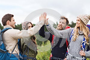 Group of smiling friends with backpacks hiking