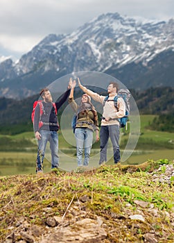 Group of smiling friends with backpacks hiking