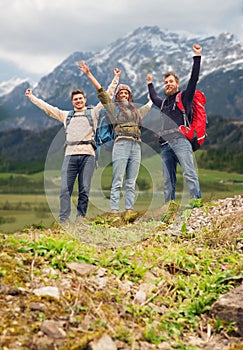 Group of smiling friends with backpacks hiking