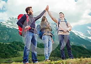 Group of smiling friends with backpacks hiking