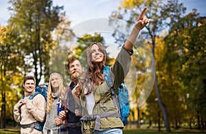 Group of smiling friends with backpacks hiking