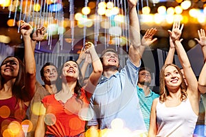 Group of smiling friends at concert in club