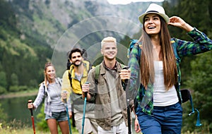 Group of smiling friends hiking with backpacks outdoors. Travel, tourism, hike and people concept.