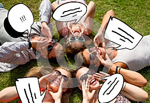 Group of smiling friends lying on grass outdoors