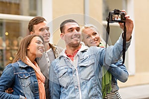 Group of smiling friends making selfie outdoors