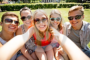 Group of smiling friends making selfie in park