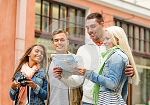 Group of smiling friends with map and photocamera