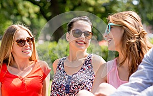 Group of smiling friends outdoors sitting in park