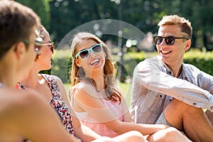 Group of smiling friends outdoors sitting in park