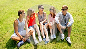 Group of smiling friends outdoors sitting in park