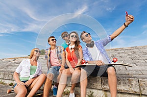 Group of smiling friends with smartphone outdoors