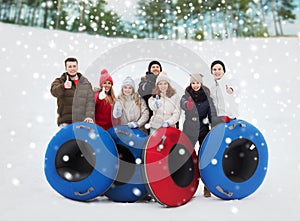 Group of smiling friends with snow tubes