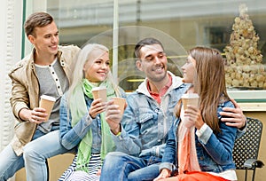 Group of smiling friends with take away coffee