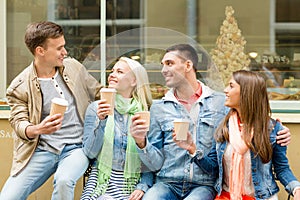 Group of smiling friends with take away coffee