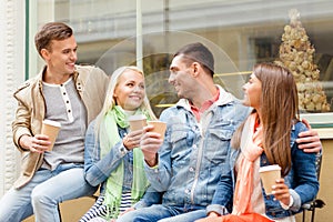 Group of smiling friends with take away coffee