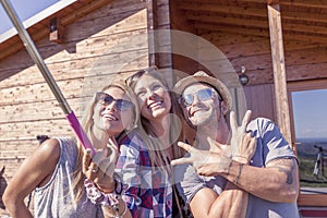 Group of smiling friends taking funny selfie with smart phone