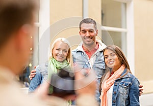 Group of smiling friends taking photo outdoors