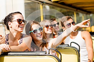 Group of smiling friends traveling by tour bus