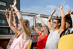 Group of smiling friends traveling by tour bus