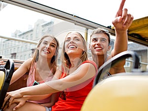 Group of smiling friends traveling by tour bus