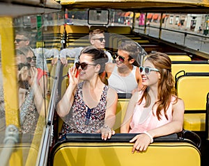 Group of smiling friends traveling by tour bus