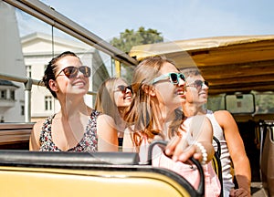 Group of smiling friends traveling by tour bus