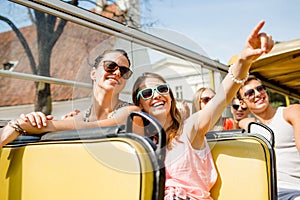 Group of smiling friends traveling by tour bus