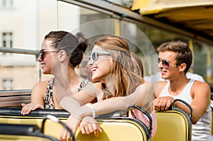 Group of smiling friends traveling by tour bus