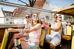 Group of smiling friends traveling by tour bus