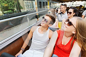 Group of smiling friends traveling by tour bus