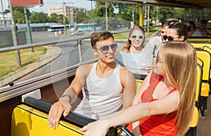 Group of smiling friends traveling by tour bus