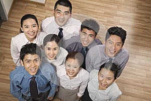 Group of smiling and happy coworkers looking up at camera, portrait, overhead shot