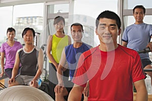 Group of smiling happy people exercising in the gym, portrait