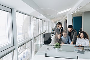 Group of smiling inspired young business people working together in office