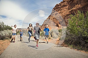 Group of smiling kids running together outdoors