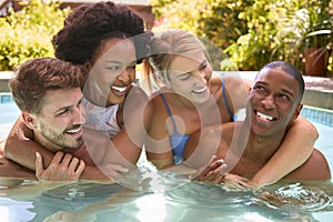Group Of Smiling Multi-Cultural Friends On Holiday In Swimming Pool 