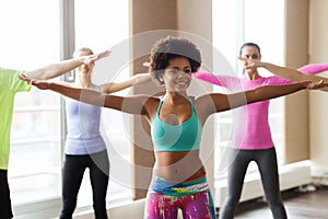 Group of smiling people dancing in gym or studio