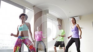 Group of smiling people dancing in gym or studio